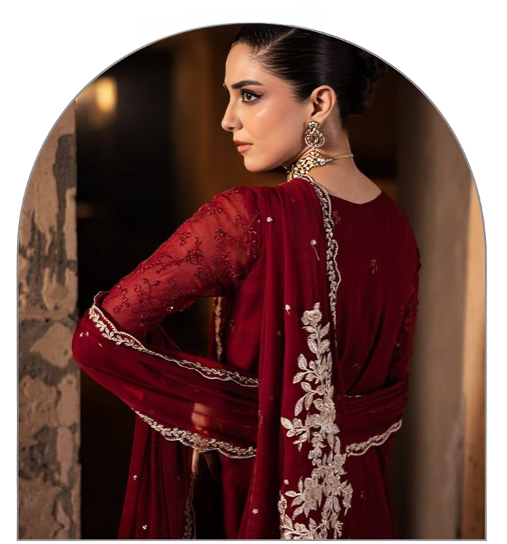 Woman wearing a red traditional outfit with intricate embroidery in a warm-toned setting